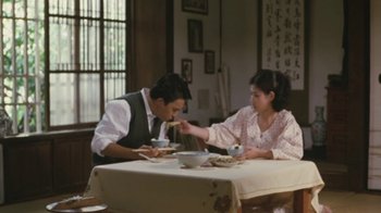 Movie still from “A City of Sadness” (1989), directed by Hsiao-Hsien Hou – A man and a woman sitting at a dinner table; Medium shot, High angle