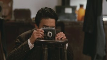 Movie still from “A City of Sadness” (1989), directed by Hsiao-Hsien Hou – A man taking a picture with a camera; Extreme Close Up shot, High angle