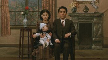 Movie still from “A City of Sadness” (1989), directed by Hsiao-Hsien Hou – A man , woman , and child sitting in a living room; Medium shot, High angle