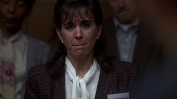 Movie still from “A Civil Action” (1998), directed by Steven Zaillian – A woman in a brown jacket and a white tie; Close Up shot, Over the shoulder angle