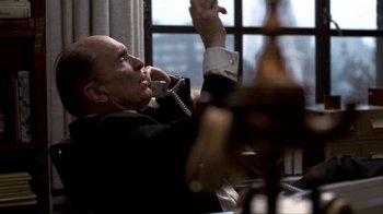 Movie still from “A Civil Action” (1998), directed by Steven Zaillian – An older man talking on a phone while sitting at a table; Medium shot, Low angle