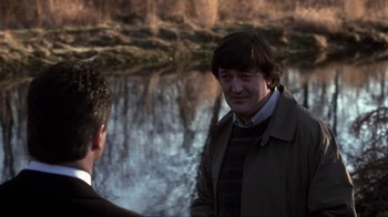 Movie still from “A Civil Action” (1998), directed by Steven Zaillian – Two men are standing near a body of water; Medium shot, Over the shoulder angle