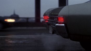 Movie still from “A Civil Action” (1998), directed by Steven Zaillian – The rear lights of a car on a rainy day; Wide shot, Low angle