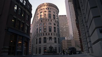 Movie still from “A Civil Action” (1998), directed by Steven Zaillian – A very tall building in the middle of a street; Extreme Wide shot, High angle
