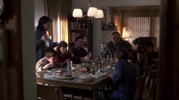 Movie still from “A Civil Action” (1998), directed by Steven Zaillian – A group of people sitting around a table eating food; Wide shot, High angle