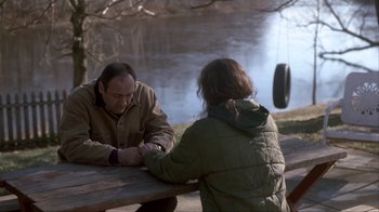 Movie still from “A Civil Action” (1998), directed by Steven Zaillian – A man and a woman sitting on a bench near a body of water; Medium shot, Over the shoulder angle