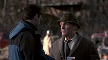 Movie still from “A Civil Action” (1998), directed by Steven Zaillian – A man wearing a hat talking to another man; Close Up shot, Over the shoulder angle