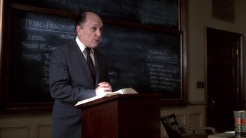 Movie still from “A Civil Action” (1998), directed by Steven Zaillian – A man standing at a podium in front of chalkboards; Medium shot, Low angle