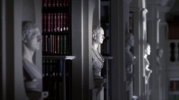 Movie still from “A Civil Action” (1998), directed by Steven Zaillian – A statue of a man in a library; Medium shot, Low angle