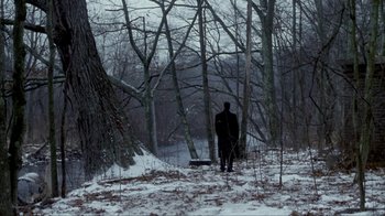 Movie still from “A Civil Action” (1998), directed by Steven Zaillian – A man standing in the middle of a snowy forest; Extreme Wide shot, Over the shoulder angle