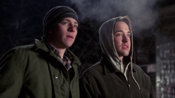 Movie still from “A Civil Action” (1998), directed by Steven Zaillian – Two young men standing next to each other in the dark; Medium shot, Low angle