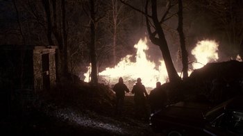 Movie still from “A Civil Action” (1998), directed by Steven Zaillian – A group of people standing in front of a fire in the woods; Extreme Wide shot, High angle