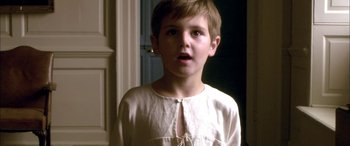 Movie still from “Tristram Shandy” (2005), directed by Michael Winterbottom – A young boy standing in front of a door; Close Up shot, High angle