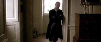Movie still from “Tristram Shandy” (2005), directed by Michael Winterbottom – A man standing in front of a window in a room; Medium shot, High angle