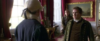 Movie still from “Tristram Shandy” (2005), directed by Michael Winterbottom – Two people in period clothing in a room; Medium shot, Over the shoulder angle