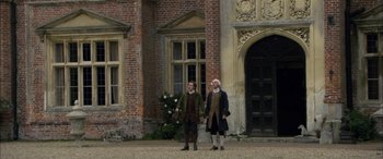 Movie still from “Tristram Shandy” (2005), directed by Michael Winterbottom – A couple of men standing next to each other on a field; Wide shot, Low angle