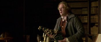 Movie still from “Tristram Shandy” (2005), directed by Michael Winterbottom – A man holding a rope in a room; Medium shot, Low angle