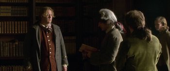 Movie still from “Tristram Shandy” (2005), directed by Michael Winterbottom – Two people in a room with a book; Medium shot, Over the shoulder angle