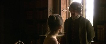 Movie still from “Tristram Shandy” (2005), directed by Michael Winterbottom – Two people are talking in front of a window in a room; Medium shot, Over the shoulder angle