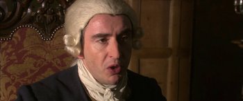 Movie still from “Tristram Shandy” (2005), directed by Michael Winterbottom – A person wearing a wig; Close Up shot, Over the shoulder angle