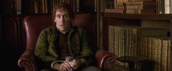 Movie still from “Tristram Shandy” (2005), directed by Michael Winterbottom – A man sitting on a chair in a room; Medium shot, Over the shoulder angle