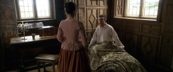 Movie still from “Tristram Shandy” (2005), directed by Michael Winterbottom – A man and a woman are sitting on a bed; Medium shot, High angle