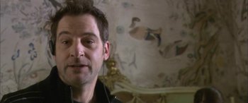 Movie still from “Tristram Shandy” (2005), directed by Michael Winterbottom – A person wearing headphones in a room; Close Up shot, Over the shoulder angle