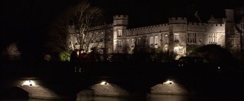 Movie still from “Tristram Shandy” (2005), directed by Michael Winterbottom – A large building lit up at night next to a river; Extreme Wide shot, High angle