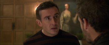 Movie still from “Tristram Shandy” (2005), directed by Michael Winterbottom – A person with a painting in the background; Close Up shot, Over the shoulder angle