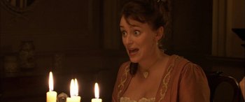 Movie still from “Tristram Shandy” (2005), directed by Michael Winterbottom – A young woman in a medieval dress with candles in the background; Close Up shot, High angle