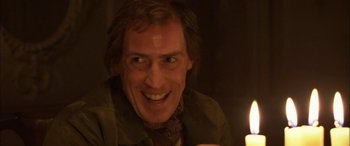 Movie still from “Tristram Shandy” (2005), directed by Michael Winterbottom – A person smiling with a candle; Close Up shot, Low angle
