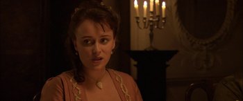 Movie still from “Tristram Shandy” (2005), directed by Michael Winterbottom – A young woman in a medieval dress in front of candles; Close Up shot, Over the shoulder angle