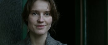 A woman's face in a gray sweater