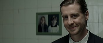 A man in front of a picture of a woman