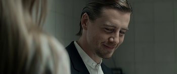 Movie still from “Department Q: A Conspiracy of Faith” (2016), directed by Hans Petter Moland – A person wearing a suit and tie; Close Up shot, Over the shoulder angle