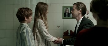 Movie still from “Department Q: A Conspiracy of Faith” (2016), directed by Hans Petter Moland – A man and a woman holding hands with a little girl; Medium shot, Over the shoulder angle
