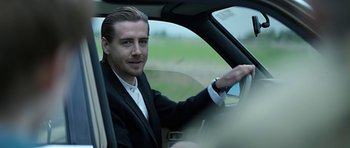 Movie still from “Department Q: A Conspiracy of Faith” (2016), directed by Hans Petter Moland – A man sitting in a car in the driver's seat of a car; Close Up shot, Over the shoulder angle