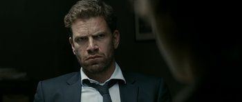 Movie still from “Department Q: A Conspiracy of Faith” (2016), directed by Hans Petter Moland – A person wearing a suit and tie; Close Up shot, Over the shoulder angle