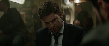 Movie still from “Department Q: A Conspiracy of Faith” (2016), directed by Hans Petter Moland – A person wearing a suit and tie; Close Up shot, Over the shoulder angle