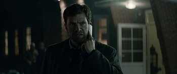 Movie still from “Department Q: A Conspiracy of Faith” (2016), directed by Hans Petter Moland – A man holding a cell phone up to his ear; Close Up shot, Low angle