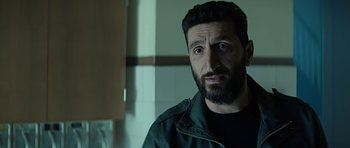 Movie still from “Department Q: A Conspiracy of Faith” (2016), directed by Hans Petter Moland – A man with a goatee and a black jacket; Close Up shot, Over the shoulder angle