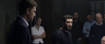Movie still from “Department Q: A Conspiracy of Faith” (2016), directed by Hans Petter Moland – A group of people standing next to each other in front of a mirror; Medium shot, Over the shoulder angle