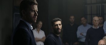 Movie still from “Department Q: A Conspiracy of Faith” (2016), directed by Hans Petter Moland – A group of men standing next to each other in a room; Medium shot, Over the shoulder angle
