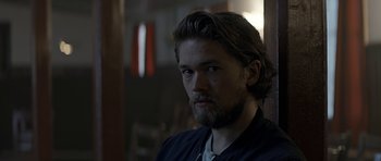 Movie still from “Department Q: A Conspiracy of Faith” (2016), directed by Hans Petter Moland – A person with a beard looking at the camera; Close Up shot, Over the shoulder angle