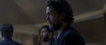 Movie still from “Department Q: A Conspiracy of Faith” (2016), directed by Hans Petter Moland – A man with long hair and a goatee is looking into the distance; Close Up shot, Over the shoulder angle