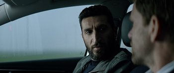 Movie still from “Department Q: A Conspiracy of Faith” (2016), directed by Hans Petter Moland – A man sitting in the driver's seat of a car; Close Up shot, Over the shoulder angle