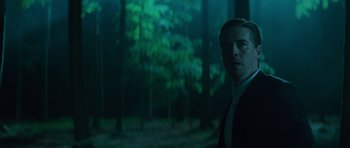 Movie still from “Department Q: A Conspiracy of Faith” (2016), directed by Hans Petter Moland – A man standing in the middle of a dark forest; Medium shot, Low angle