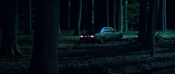 Movie still from “Department Q: A Conspiracy of Faith” (2016), directed by Hans Petter Moland – A car parked in the middle of a forest at night; Extreme Wide shot, High angle