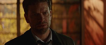 Movie still from “Department Q: A Conspiracy of Faith” (2016), directed by Hans Petter Moland – A person wearing a suit and tie; Close Up shot, Over the shoulder angle