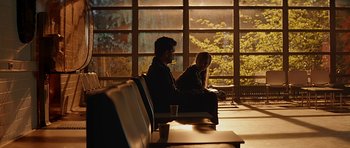 Movie still from “Department Q: A Conspiracy of Faith” (2016), directed by Hans Petter Moland – A man and a woman sitting on a bench in front of a window; Wide shot, Over the shoulder angle